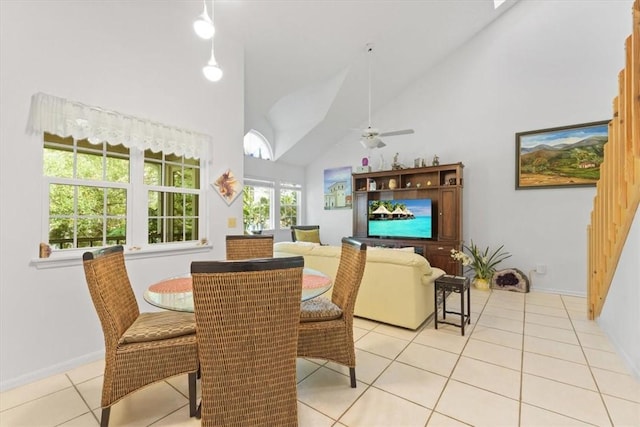 dining room featuring light tile patterned floors, a ceiling fan, baseboards, and high vaulted ceiling