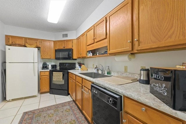 kitchen featuring visible vents, black appliances, a sink, light countertops, and light tile patterned floors