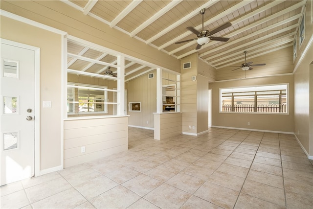 spare room featuring beam ceiling, plenty of natural light, light tile patterned flooring, and wood ceiling