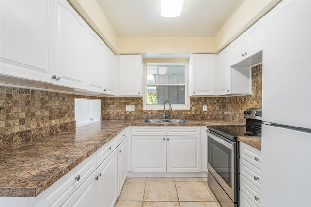 kitchen featuring stainless steel electric stove, sink, white cabinets, and white refrigerator