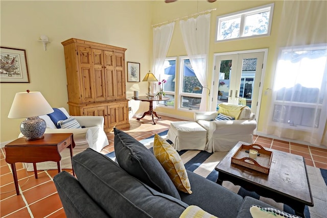 living room with a healthy amount of sunlight, a towering ceiling, and light tile patterned floors