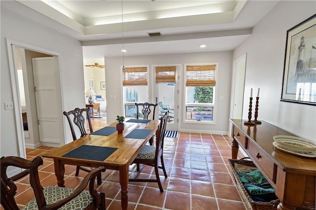 dining space featuring visible vents, a raised ceiling, baseboards, dark tile patterned floors, and recessed lighting