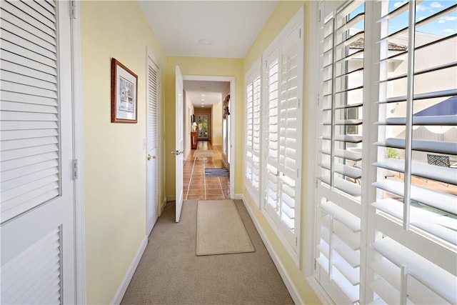 corridor with carpet and baseboards