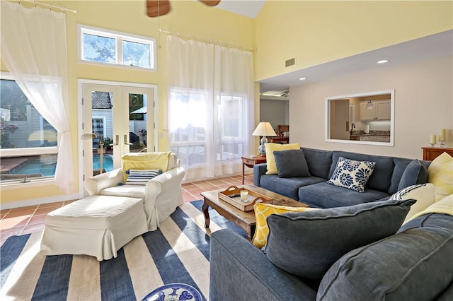 living area with tile patterned floors, visible vents, a ceiling fan, and french doors