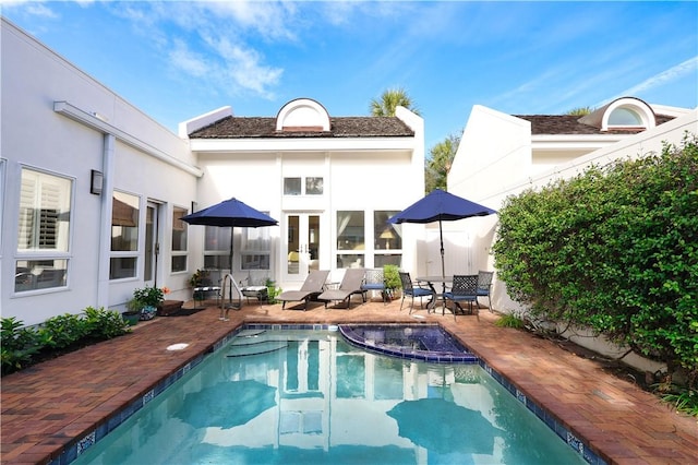 outdoor pool featuring french doors and a patio