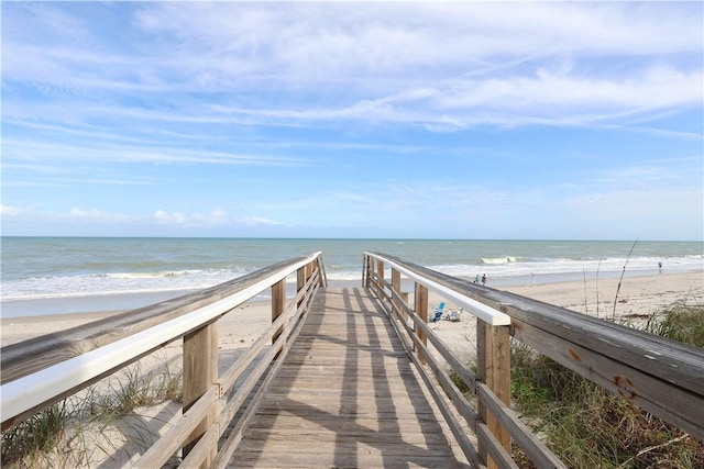 view of home's community with a water view and a beach view