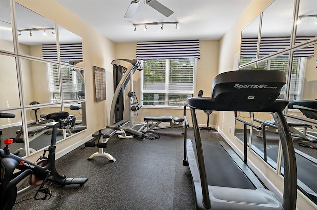 exercise room with ceiling fan, baseboards, and track lighting