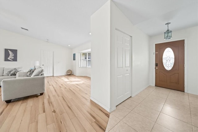 entryway featuring light wood-type flooring and vaulted ceiling