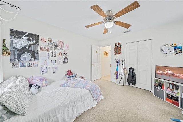 bedroom featuring ceiling fan, a closet, and light carpet