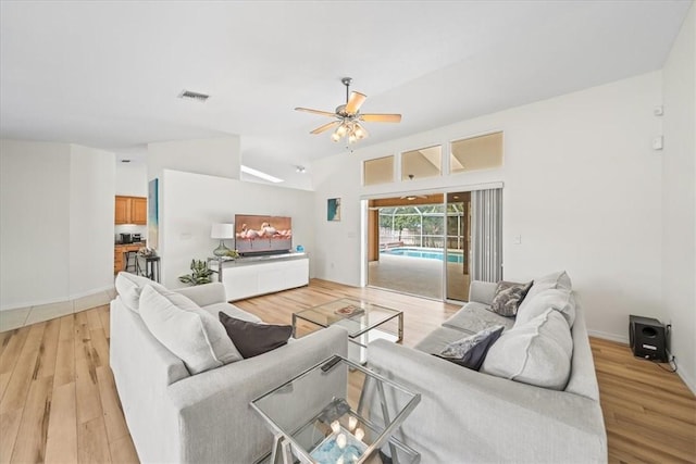 living room with ceiling fan, light hardwood / wood-style floors, and lofted ceiling