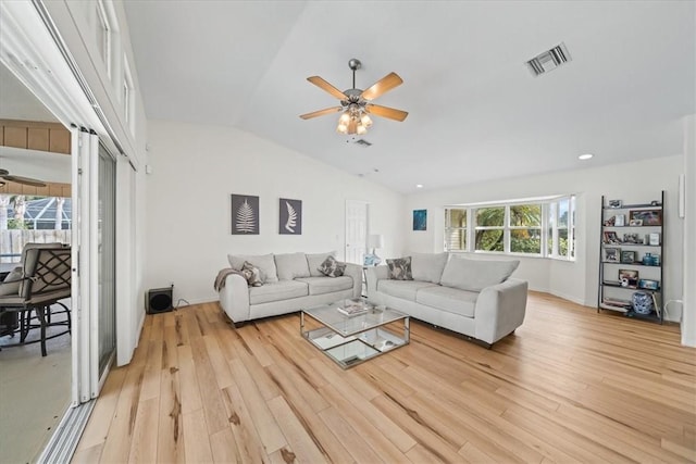 living room featuring ceiling fan, vaulted ceiling, and light wood-type flooring