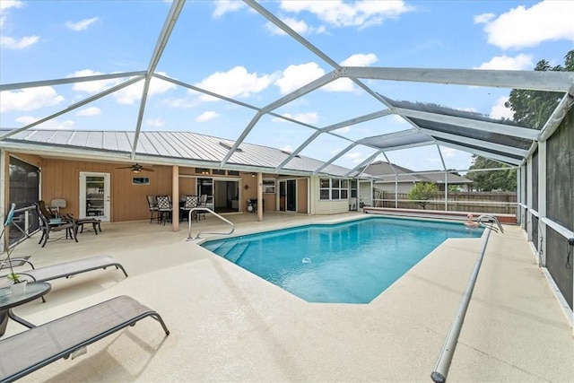 view of swimming pool with ceiling fan, a lanai, and a patio