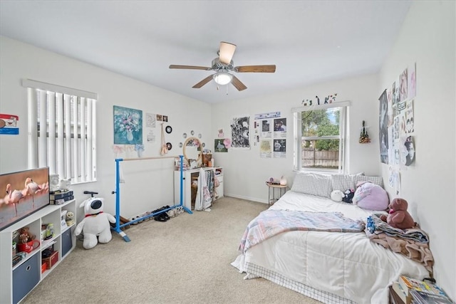 carpeted bedroom featuring ceiling fan and multiple windows