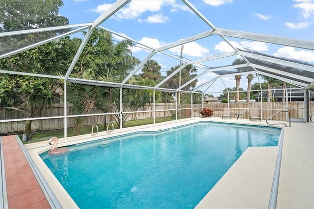 view of pool with glass enclosure and a patio area