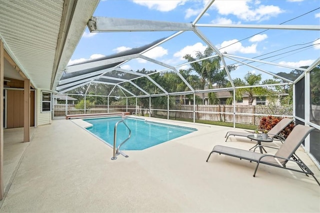 view of pool with a patio area and glass enclosure