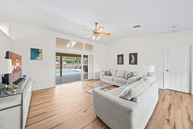 living room featuring vaulted ceiling, ceiling fan, and light hardwood / wood-style floors