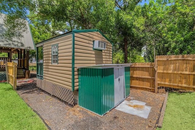 view of shed featuring fence and an AC wall unit