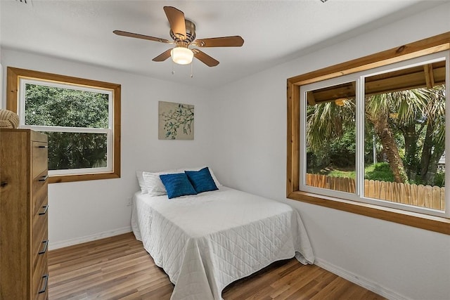 bedroom with baseboards, ceiling fan, and wood finished floors