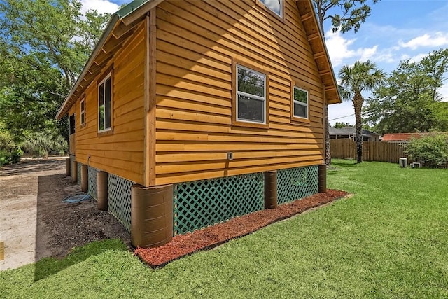 view of side of home featuring a yard and fence