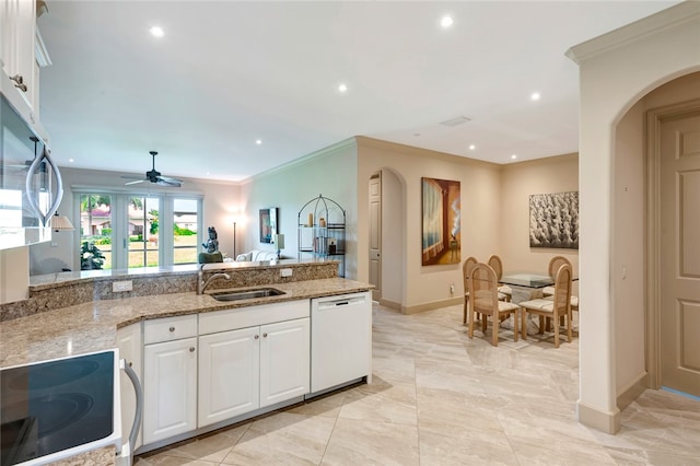 kitchen with light stone countertops, dishwasher, white cabinets, and sink