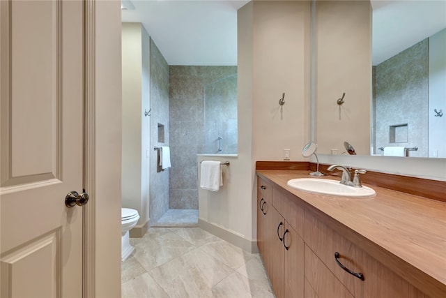 bathroom with vanity, toilet, and a tile shower