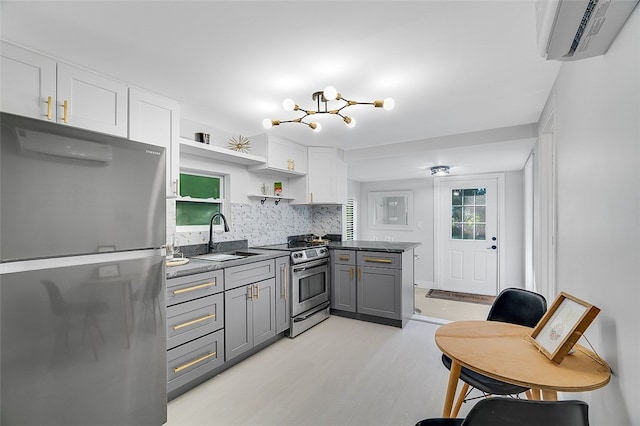 kitchen featuring appliances with stainless steel finishes, a wall mounted air conditioner, sink, gray cabinetry, and white cabinets