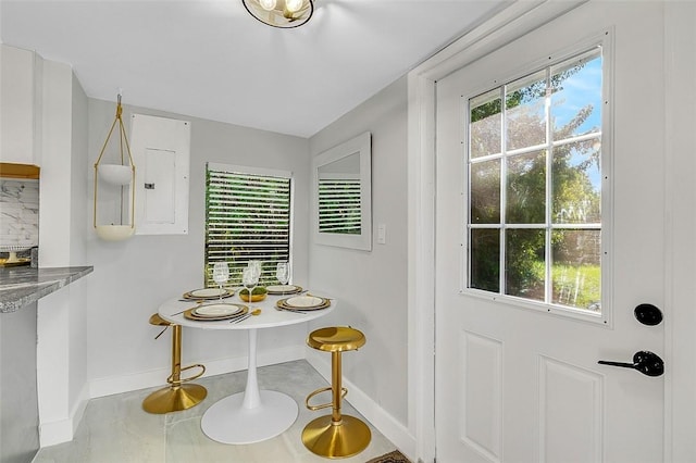 kitchen featuring a breakfast bar, white cabinetry, backsplash, a wall unit AC, and kitchen peninsula