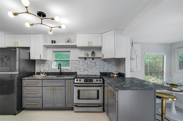 kitchen with black refrigerator, white cabinetry, gray cabinetry, backsplash, and electric stove