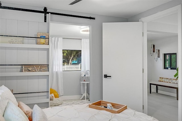 bedroom with ceiling fan, a wall mounted air conditioner, and a barn door