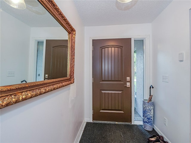 foyer entrance with a textured ceiling