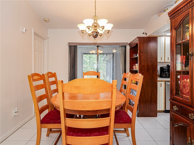 tiled dining area featuring a textured ceiling and a chandelier