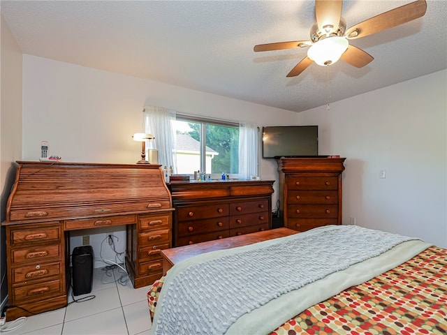 bedroom with light tile patterned floors, a textured ceiling, and ceiling fan