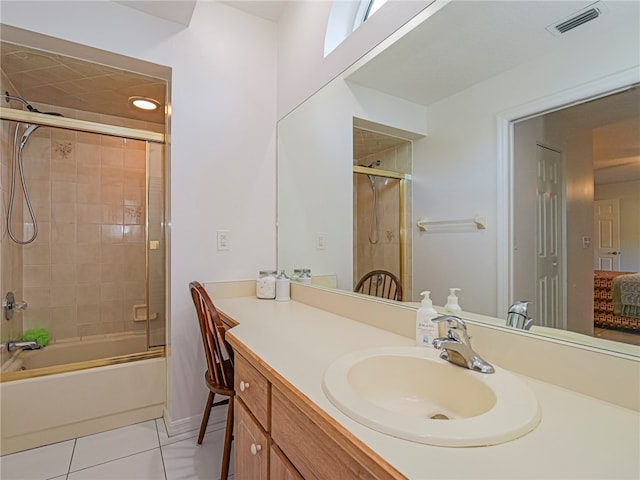 bathroom featuring tile patterned flooring, vanity, and enclosed tub / shower combo