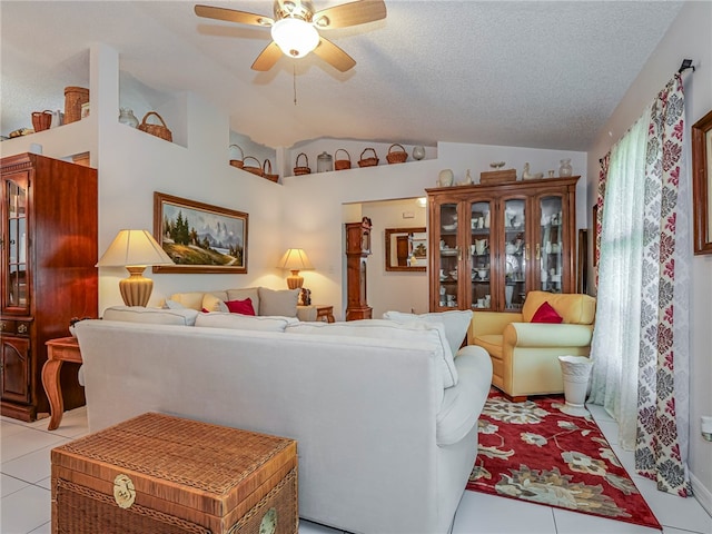 tiled living room with ceiling fan, lofted ceiling, and a textured ceiling