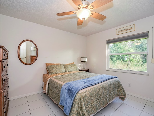 tiled bedroom featuring ceiling fan and a textured ceiling