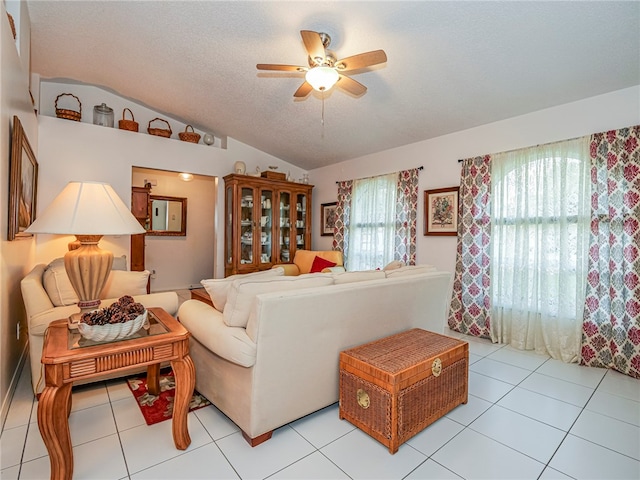 tiled living room with a textured ceiling, ceiling fan, and lofted ceiling