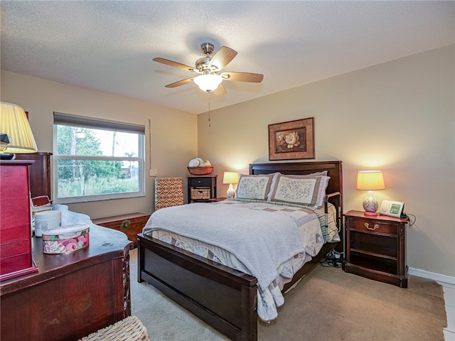 carpeted bedroom featuring ceiling fan and a textured ceiling