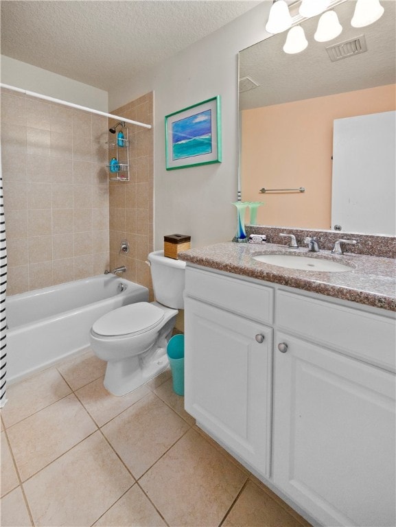 full bathroom with toilet, tile patterned floors, a textured ceiling, tiled shower / bath combo, and vanity