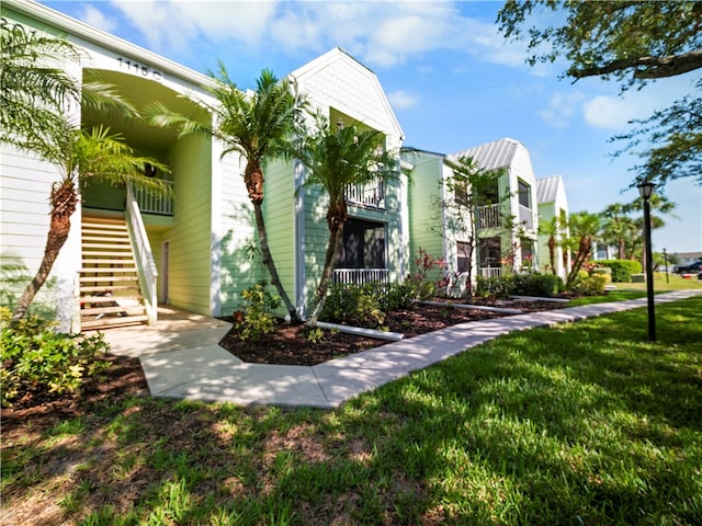 view of front facade with a front lawn and a balcony