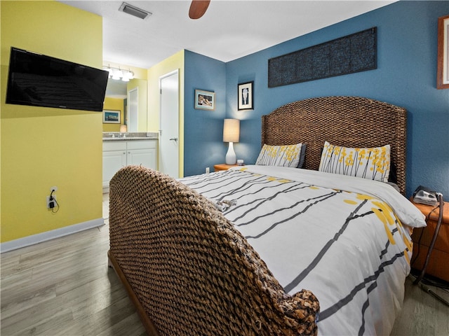 bedroom featuring ensuite bath, wood-type flooring, and ceiling fan