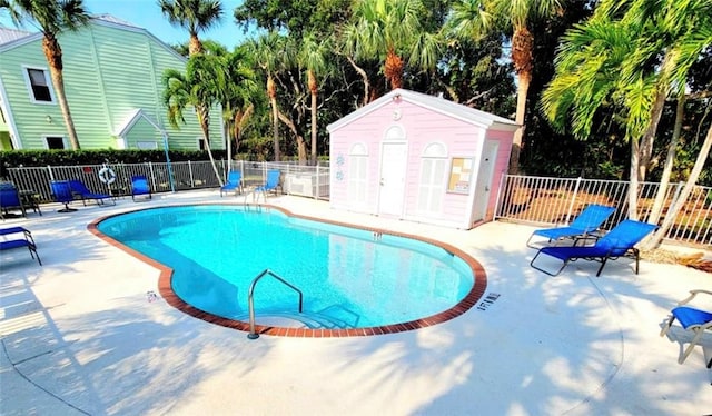 view of swimming pool with a patio and an outdoor structure