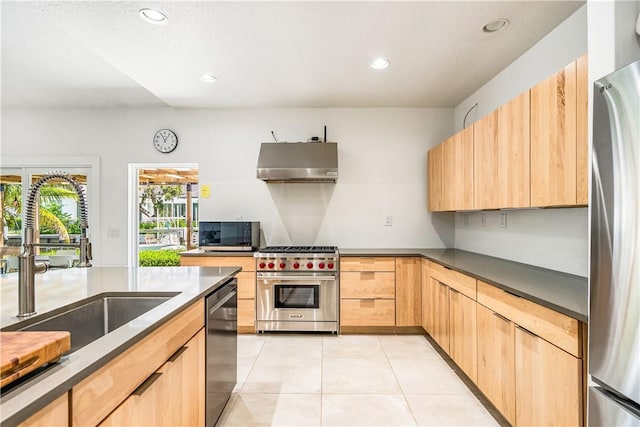 649 E Causeway Blvd, Vero Beach, FL 32963 - kitchen featuring appliances with stainless steel finishes, wall chimney exhaust hood, light brown cabinetry, light tile patterned floors, and recessed lighting
