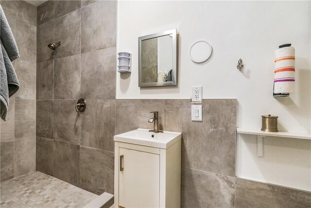 649 E Causeway Blvd, Vero Beach, FL 32963 - bathroom with tiled shower, vanity, and tile walls