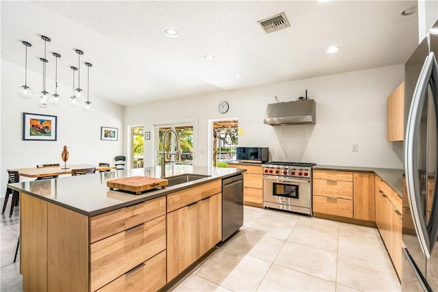 649 E Causeway Blvd, Vero Beach, FL 32963 - kitchen featuring stainless steel appliances, under cabinet range hood, modern cabinets, light brown cabinetry, and an island with sink