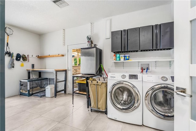 649 E Causeway Blvd, Vero Beach, FL 32963 - laundry room with cabinet space, independent washer and dryer, light tile patterned floors, and a textured ceiling