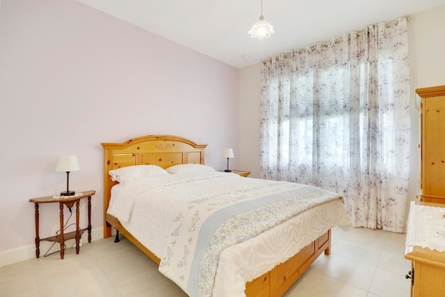 bedroom featuring light tile patterned floors and baseboards