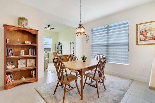 dining space with light tile patterned flooring, baseboards, and ceiling fan