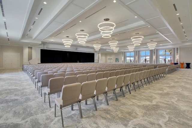 carpeted cinema with a raised ceiling