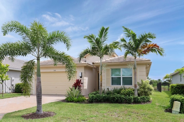 view of front of property featuring stucco siding, decorative driveway, fence, a front yard, and a garage