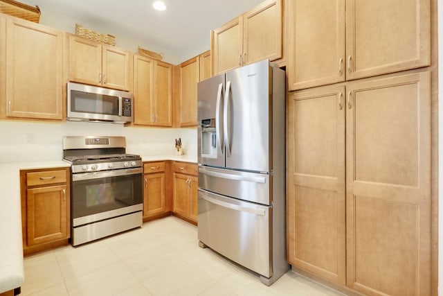 kitchen featuring light countertops, light brown cabinets, and stainless steel appliances